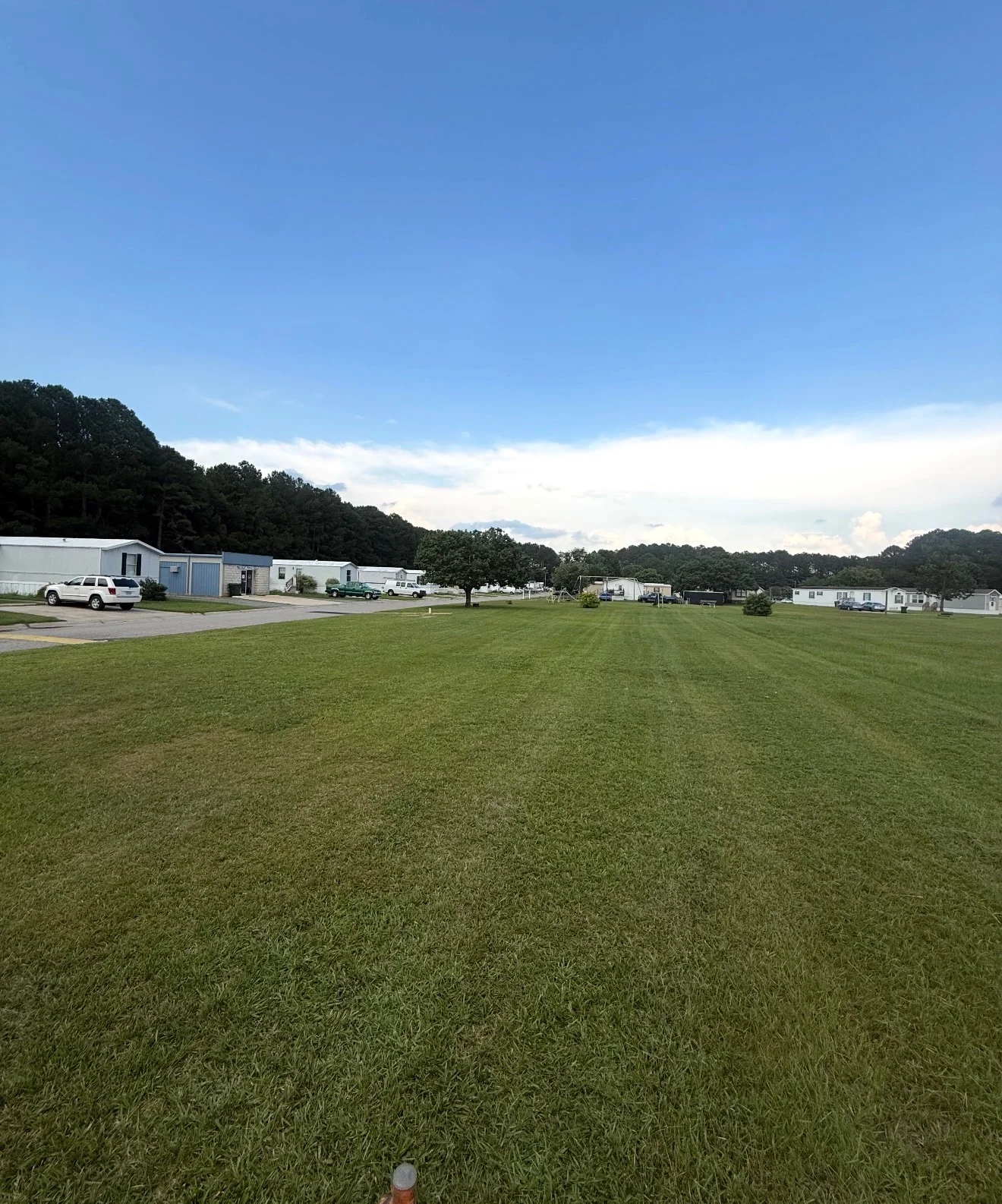 Long parallel mowing lines cross a wide open lawn. YardU project photo.
