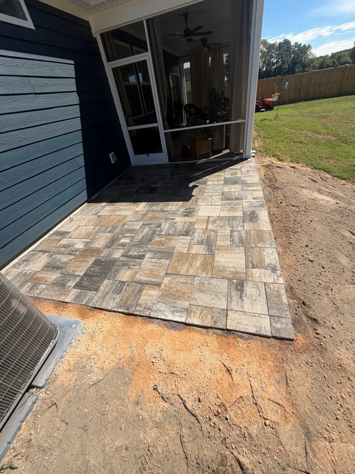 A patterned paver walkway leads along the side of the house to the rear door. YardU project photo.